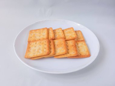 Şeker kaplı bisküviler, malkist olarak da bilinir, tatlı ve çıtır çıtır. Beyaz tabakta servis edilir.