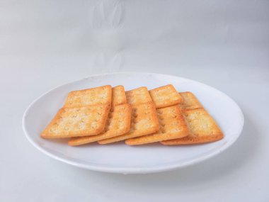 Şeker kaplı bisküviler, malkist olarak da bilinir, tatlı ve çıtır çıtır. Beyaz tabakta servis edilir.