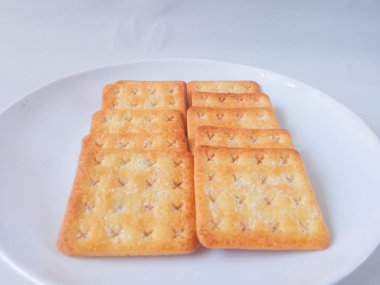 Şeker kaplı bisküviler, malkist olarak da bilinir, tatlı ve çıtır çıtır. Beyaz tabakta servis edilir.