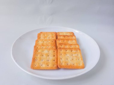 Şeker kaplı bisküviler, malkist olarak da bilinir, tatlı ve çıtır çıtır. Beyaz tabakta servis edilir.