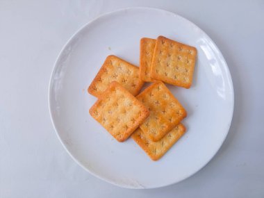 Şeker kaplı bisküviler, malkist olarak da bilinir, tatlı ve çıtır çıtır. Beyaz tabakta servis edilir.