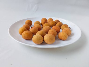 Beyaz bir plaka üzerindeki longan meyvesi beyaz arka planda izole edilir