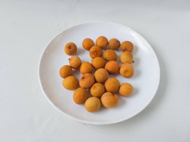 Beyaz bir plaka üzerindeki longan meyvesi beyaz arka planda izole edilir