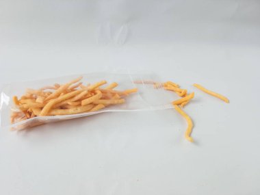 Soğan çubuğu atıştırmalıkları, yukarıda plastik ambalaj mikalarında lezzetli atıştırmalıklar beyaz arka planda izole edilmiş mika..