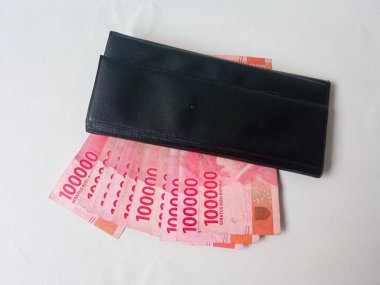 uang beyaz arka planda izole edilmiş siyah bir cüzdanda yüz bin rupiah
