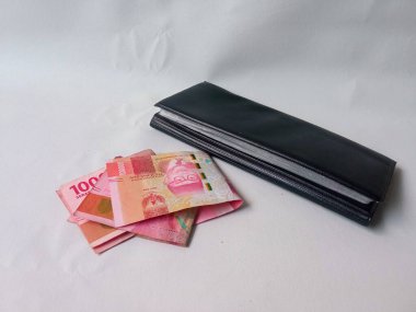 uang beyaz arka planda izole edilmiş siyah bir cüzdanda yüz bin rupiah