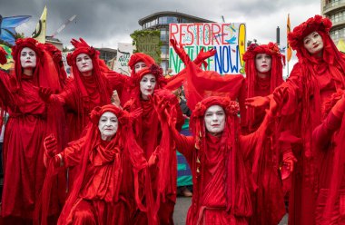 Londra / İngiltere - 22 Haziran 2024: Red Rebel Brigade iklim aktivistleri Doğayı Yenileme Yürüyüşü çevresel koruma için yürüdüler. RSPB, WWF, National Trust, Extinction Rebellion ve diğerleri de dahil olmak üzere örgütler