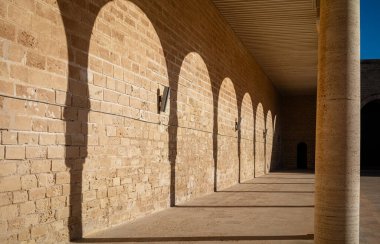 Geleneksel İslami at nalı kemerlerinin gölgeleri sahilin kenarında, ya da avluda, Tunus 'taki Mahdia Büyük Camii' nde..