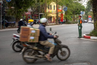 Vietnamlı bir asker motosiklet trafiği sırasında Dien Bien Phu, Hanoi, Vietnam 'daki askeri tesislerin yakınında nöbet tutuyor..