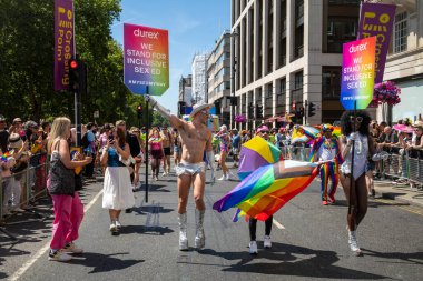 Londra / İngiltere - 29 Haziran 2024: Londra 'da düzenlenen yıllık Onur Yürüyüşü' nde insanlar Durex afişleriyle yürüyor. Kutlama, LGBTQ + topluluklarından insanları bir araya getiriyor.
