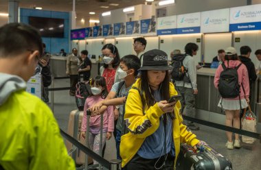 Çinli yolcular, Londra Gatwick Havaalanı, İngiltere 'den Şangay' a gidecek Çin doğulu bir uçağa giriş yapmak için kuyruğa girdiler..