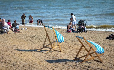 Essex, İngiltere 'de Southend-on-Sea sahilinde rüzgarda dalgalanan iki boş şezlong..