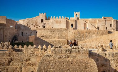 Women on a walkway within the Ribat of Monastir, an 8th century Islamic coastal fortress,  Monastir, Tunisia. clipart