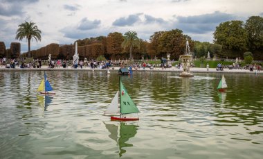 Fransa 'nın başkenti Paris' te popüler Jardin du Lüksemburg 'un gölet boyunca süzülen model yelkenliler..