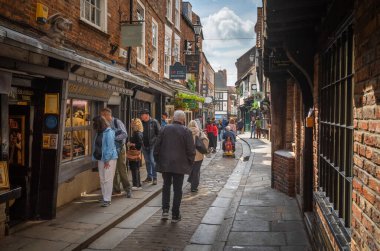 Turistler, İngiltere 'nin Kuzey Yorkshire, York' taki korunmuş ortaçağ sokağı Shambles 'ı keşfediyorlar..