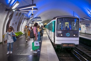 Paris Metro treni Paris, Fransa 'daki 4. hat üzerinde Gambetta İstasyonu' na yanaşırken yolcular platformda bekliyorlar..