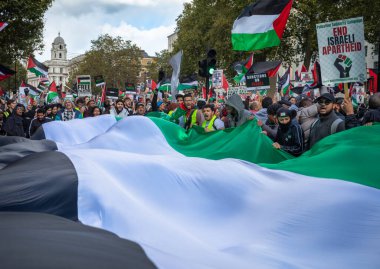 Londra, İngiltere. 14 Ekim 2023: Barışçıl Filistin yanlısı protestocular, İsrail 'in Gazze' ye düzenlediği saldırılara karşı İngiltere 'nin orta kesimindeki Whitehall' da bir Filistin bayrağı tutuyorlar..
