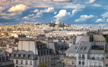 Pompidou Merkezi 'nden kuzeye, Sacr-Cur de Montmartre Bazilikası' na (Kutsal Yürek Bazilikası) doğru bakan Paris 'in çatılarından bir manzara tepenin üstünde yer alır.. 