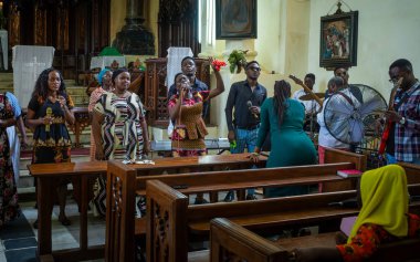 Pazar günü, Stone Town, Zanzibar, Tanzanya 'daki Anglikan İsa Kilisesi Katedrali' nde bir kadın ve diğer ibadet edenler olarak bir grup çalıyor.