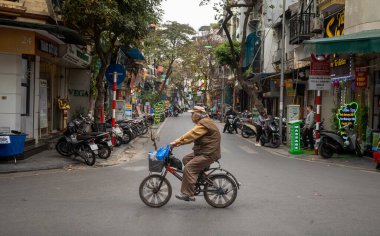 Yaşlı bir Vietnamlı bisikletini Hang Bac 'te sürüyor. Hanoi' nin eski mahallesinde, Vietnam 'da.