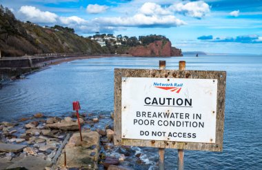 Network Demiryolu 'ndan bir işaret dalgakıranın kötü durumda olduğunu söylüyor, Teignmouth, Devon, İngiltere.