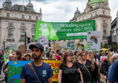 Londra / İngiltere - 22 Haziran 2024: Ulusal Tröst eylemcileri Çevre Koruma için Doğayı Yenileme Yürüyüşü 'nde. Yürüyüş için RSPB, WWF, National Trust, Extinction Rebellion ve diğerleri de dahil olmak üzere 350 örgüt.