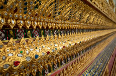 Intricate gold and coloured decorations on the exterior of a temple at Wat Arun, or the Temple of Dawn, in Bangkok, Thailand. clipart