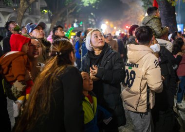 Sarı saçlı Vietnamlı bir kadın Tet 'te ya da Yeni Yıl' da, Hanoi, Vietnam 'da havai fişek gösterisi izlemek için kalabalığın arasında duruyor..