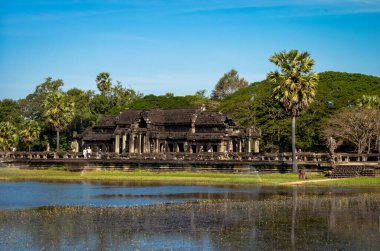 Az sayıda yabancı turist, Kamboçya 'daki Angkor Wat tapınağındaki antik bir kütüphanenin önünden geçerek geçtiler..