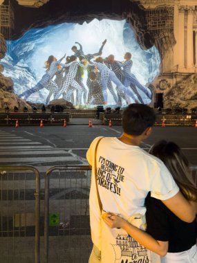 Paris 'te Palais Garnier' in önünde sarılan iki genç sevgili. Fransız sanatçı JR dış iskeleye dansçıların yansıttığı geniş bir mağarayı temsil etmek için sardı..