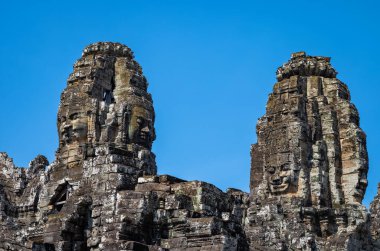 Angkor Thom 'daki Angkor Kamboçya' daki antik Bayon Tapınağı 'nın taşına oyulmuş dev yüzler..