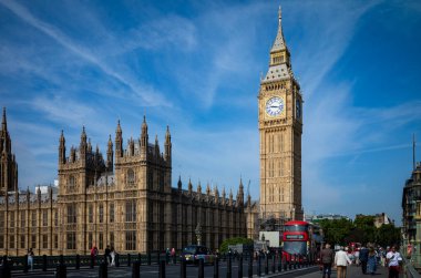 İnsanlar Londra, İngiltere 'deki Parlamento Binaları ve Big Ben' in yanındaki Westminster Köprüsü 'nde geziniyor.