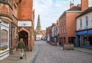 Gündoğumunda yaşlı bir adam, İngiltere 'nin Staffordshire kentindeki bu antik ve tarihi şehirde, ana kulesi restore edilmiş bir şekilde, Lichfield Katedrali manzarası ile Conduit Caddesi' nde yürüyor..
