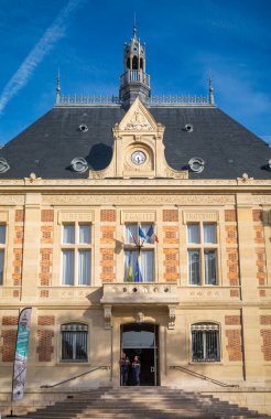 Two police officers stand in front of the Mairie de Montrouge, or Montrouge Town Hall, in Montrouge,  a suburb just south of Paris, France. clipart