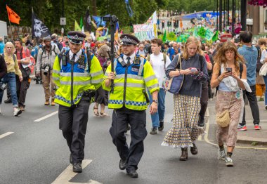 Londra İngiltere - 22 Haziran 2024: İki Metropolitan Polis Memuru, Londra, İngiltere 'deki Doğayı Yenileme Gösterisini kaydetmek için bir video kamera taşıyorlar