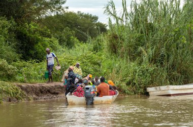 Köylüler, Tanzanya 'daki Nyerere Milli Parkı' ndan (Selous Game Reserve) Mwaseni 'deki Rufiji Nehri' nden geçen küçük bir feribota biniyorlar..