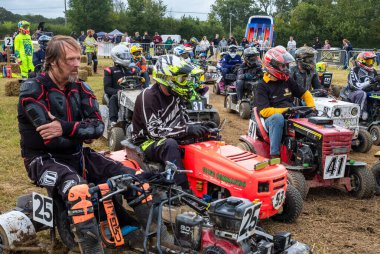 Sürücüler yarış çim biçme makinelerinde otururken Le Mans stili İngiliz Çim biçme Yarışı Derneği dayanıklılığı BLMRA 500 Billingshurst, West Sussex, İngiltere 'de başlangıç pozisyonlarını bekliyorlar.