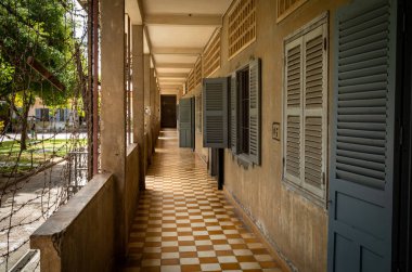 Kamboçya 'nın Phnom Penh kentindeki ünlü Tuol Sleng S-21 işkence ve soykırım hapishane müzesinin eski sınıflarının önünden geçen bir koridor.