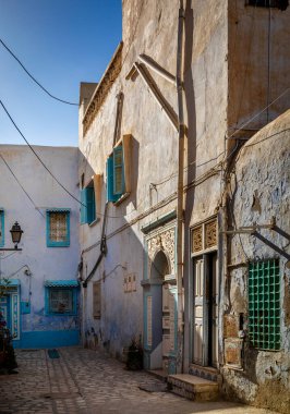 Kairouan, Tunus 'taki bir avluda eski beyaz, mavi ve sarı evler. Kairouan İslam 'ın dördüncü en kutsal şehridir ve UNESCO' nun Dünya Mirasları Alanıdır..