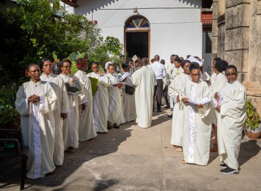 Beyazlar içindeki koro, Taş Şehir, Zanzibar, Tanzanya 'daki Katolik Pazar Ayini için St. Joseph Katedrali' ne girmek için bekliyor..