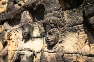 Kamboçya 'daki Angkor kompleksindeki Lweper King' in terasında kumtaşına oyulmuş eski ve yıpranmış yüzler..
