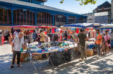 İnsanlar, Troyes, Aube, Fransa 'daki Merkez Pazarı' nın (Marche des Halles) dışındaki meydanda bir ev eşyası ve giyim tezgahına göz atıyorlar..