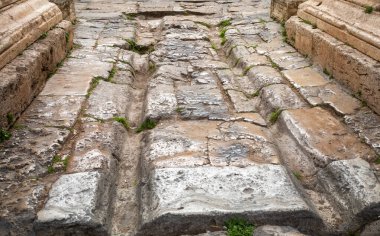 The deeply rutted pavement of  the Roman-era roadway that passes through Hadrian's Gate, a beautifully preserved ancient archway in Kaleici, Antalya, Turkey (Turkiye).  clipart