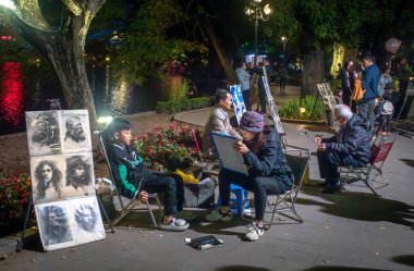 Sokak sanatçıları gece Hoan Kiem Gölü 'nün yanındaki insanların portrelerini çiziyor..