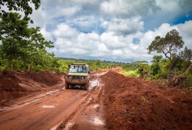 Tanzanya kırsalında Msanga yakınlarındaki ıslak ve çamurlu bir toprak yoldan geçen 4 tekerli bir araç..