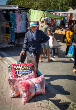 An elderly man waits with nedding purchased at the Sunday Souk, a weekly market in Souse, Tunisia. clipart