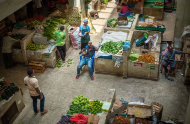 Meyve ve sebze tüccarları Doğu Afrika 'daki Dar es Salaam, Tanzanya' daki Kisutu Pazarı 'nda müşterileri bekliyorlar.