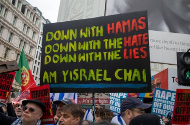 London, UK. 18 May 2024: Pro-Israel counter demonstrators hold placards at Piccadilly Circus as they shout at and taunt people marching for peace in Palestine at  the Nakba 76 March for Palestine against Israeli attacks on Gaza in central London, UK. clipart