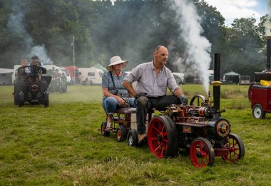 Storrington / UK - Jul 13 2024: Steam enthusiasts drive their scale model steam traction engines at Sussex Steam Fair, Parham, Storrington, UK. clipart