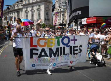 Londra / İngiltere - 29 Haziran 2024: Çocuklu eşcinsel çiftler, Londra 'da düzenlenen yıllık Onur Yürüyüşü' nde LGBTQ + aileleriyle birlikte yürüyor. Kutlama, LGBTQ + topluluklarından insanları bir araya getiriyor.